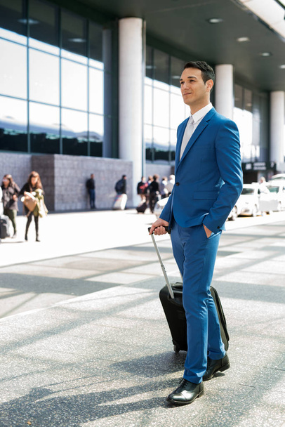 Businessman pulling a trolley in airport - 写真・画像