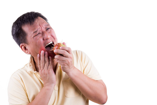 Homme conceptuel avec douleur de mal de dents après avoir mordu une pomme avec une épine
 - Photo, image