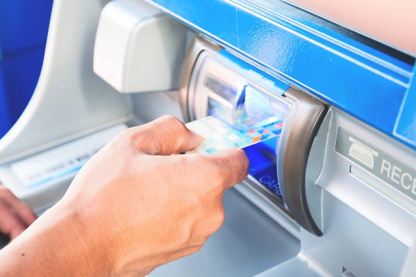 Main de l'homme insérer la carte à la machine ATM
 - Photo, image