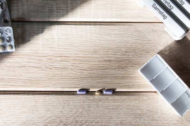 Tablettenspender auf einem Holz Hintergrund - Foto, Imagen