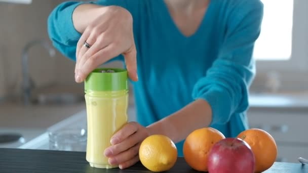 Young woman makes big glass of healthy fruits smoothie at home. - Footage, Video