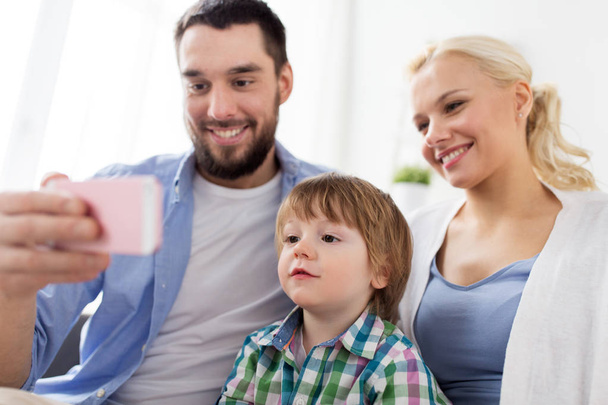 happy family with smartphone at home - Valokuva, kuva