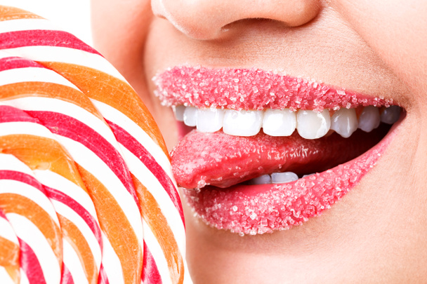Primo piano delle labbra della donna coperte di zucchero e lecca-lecca grande
 - Foto, immagini