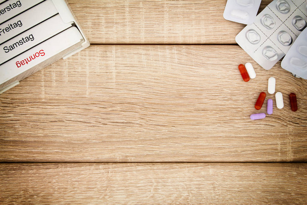 Tablettenspender auf einem Holz Hintergrund - Zdjęcie, obraz