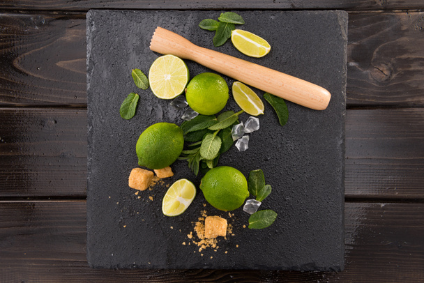 lime slices with sugar and wooden squeezer - Photo, Image