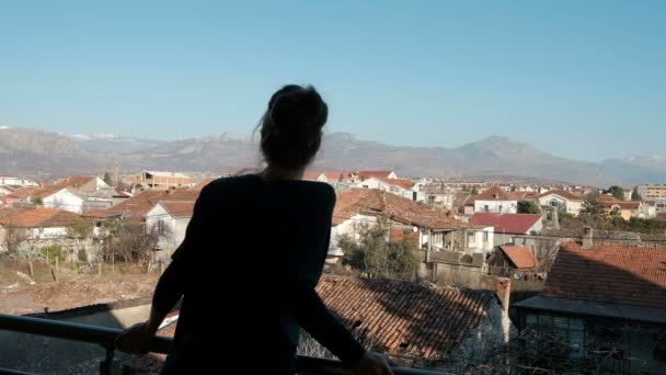Młoda kobieta podziwia krajobraz na balkonie w swoim domu. - Materiał filmowy, wideo