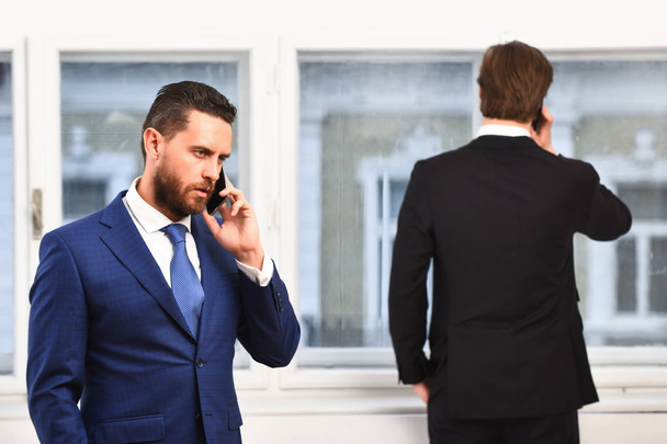 hombres o hombres de negocios serios que hablan por teléfono móvil o celular - Foto, Imagen