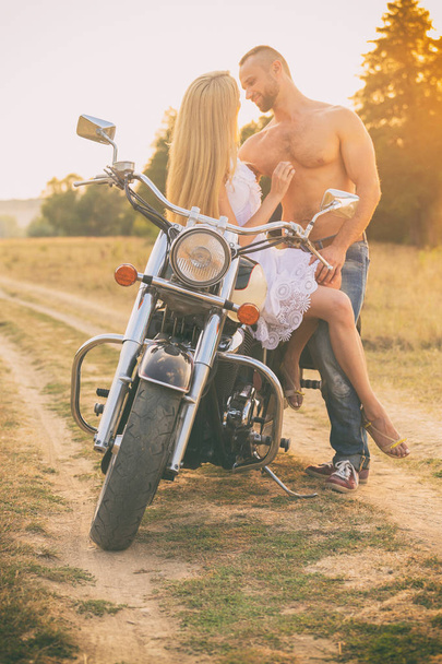 Любящая пара на мотоцикле в поле
 - Фото, изображение
