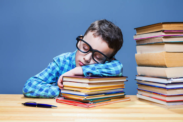 jongen slapen op stapel boeken - Foto, afbeelding