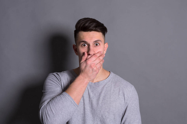 Pomlouvačná, překvapený muž pokrývající ústa rukou - Fotografie, Obrázek