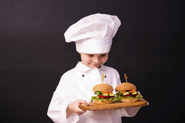 boy cook holding a hamburger - Φωτογραφία, εικόνα