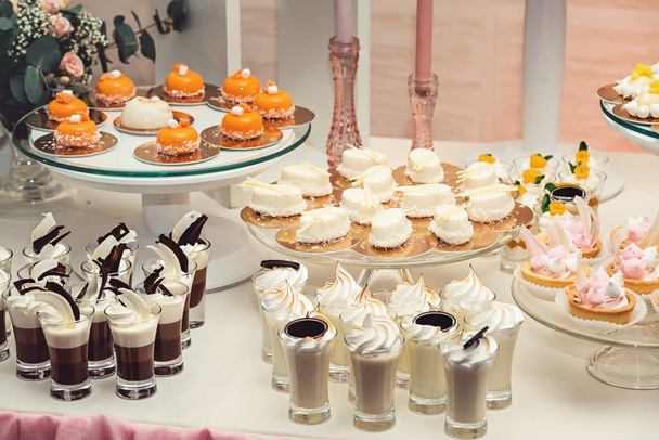 čokoládové sladkosti bílé a oranžové na zlaceném papíře o svatební bonbóny - Fotografie, Obrázek