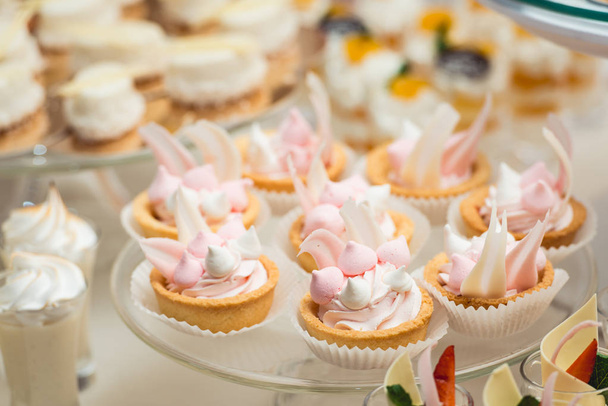скляна підставка з кексами на весільному столі з цукерками
 - Фото, зображення