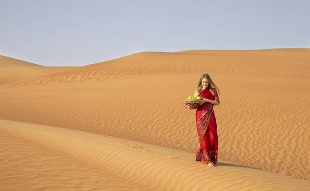 Woman in a desert with apples - Photo, Image