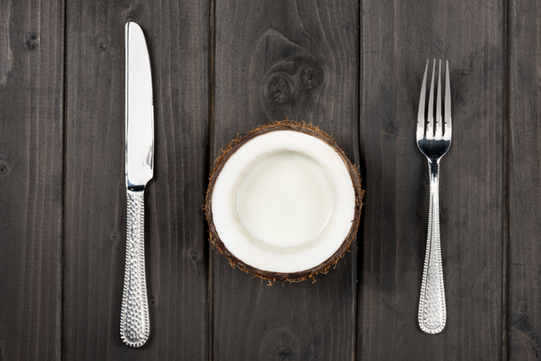 moitié noix de coco avec fourchette et couteau en métal
 - Photo, image