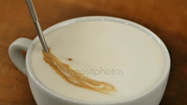 geschäumte Milch wird in eine Tasse Kaffee gegossen und macht Latte Art - Filmmaterial, Video