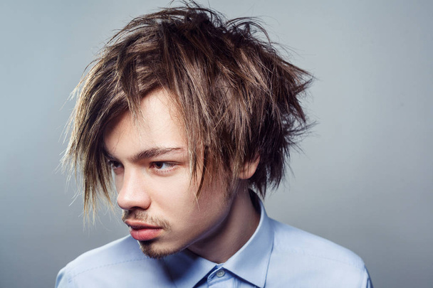 Portrait of young man with fringe messy hairstyle. studio shot. - Foto, Imagen