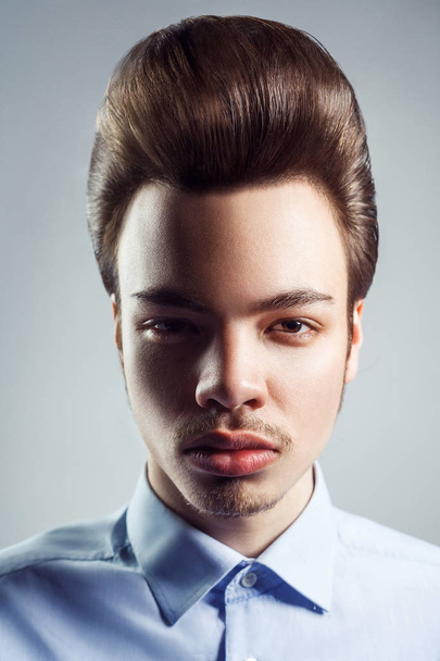 Portrait de jeune homme à la coiffure classique rétro pompadour. studio tourné. regarder la caméra
. - Photo, image