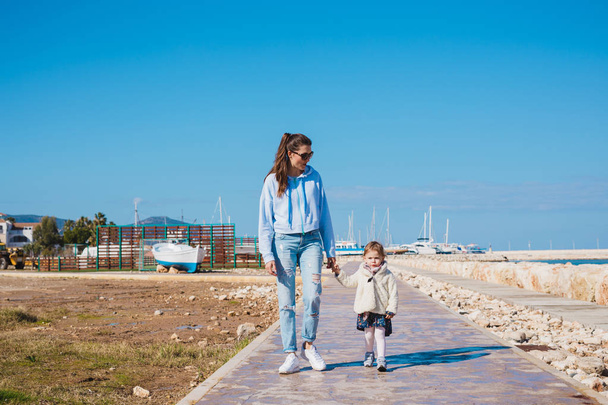 madre e hija pequeña caminando en la playa de verano
 - Foto, imagen