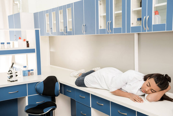 chica científica durmiendo en mesa en laboratorio
 - Foto, Imagen