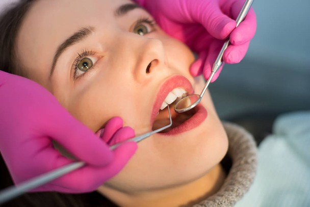 Όμορφη νεαρή γυναίκα που έχει οδοντιατρικό έλεγχο σε κοντινό πλάνο   - Φωτογραφία, εικόνα