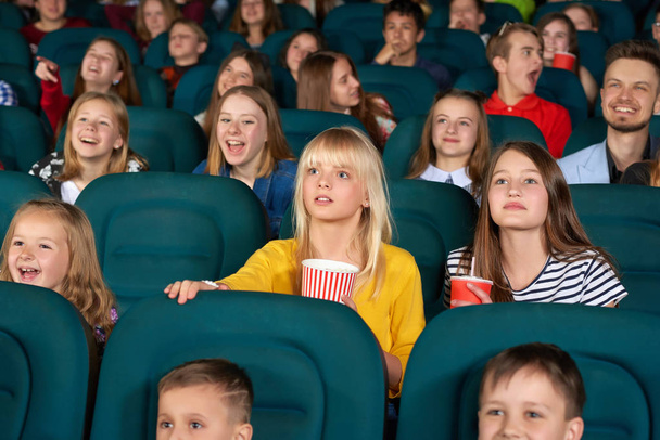 Cinema auditorium full of kids during movie premiere - Photo, image
