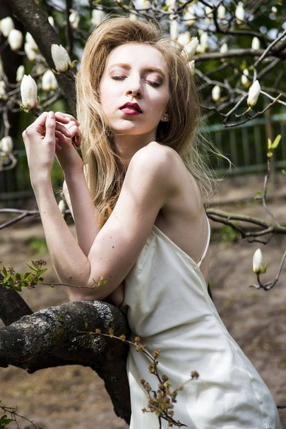 Wiosenny strój dziewczyna cebula z blond włosami w ogrodzie - Zdjęcie, obraz