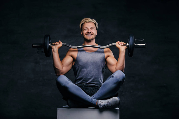 Blond sporty male holds barbell - Photo, Image