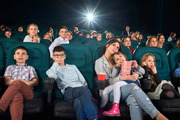 Children with parents enjoying a movie together at the cinema - Foto, immagini