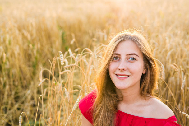 Όμορφη κοπέλα στο πεδίο σιτάρι στο ηλιοβασίλεμα - Φωτογραφία, εικόνα