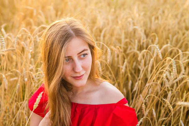 Όμορφη κοπέλα στο πεδίο σιτάρι στο ηλιοβασίλεμα - Φωτογραφία, εικόνα