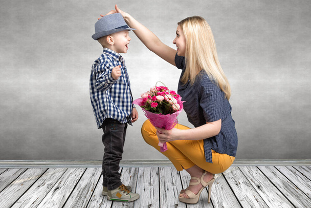 Petit fils donne à sa mère bien-aimée un beau bouquet de roses roses. Printemps, concept de vacances en famille. Fête des femmes, fête des mères
. - Photo, image