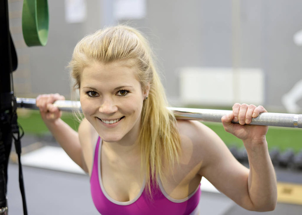 Femme soulevant des poids dans la salle de gym
 - Photo, image