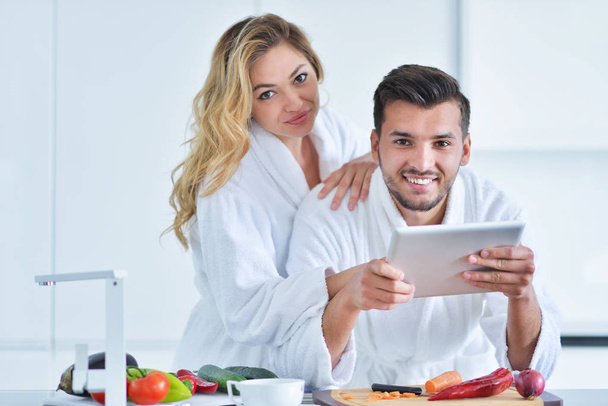 couple using tablet in the kitchen - Φωτογραφία, εικόνα