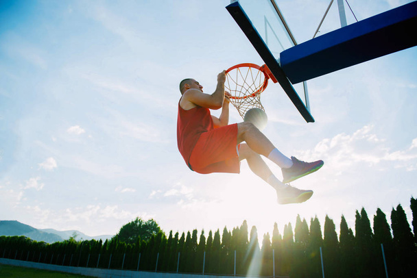 Hombre haciendo un fantástico slam dunk
  - Foto, Imagen