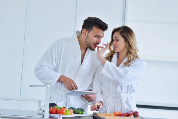Couple in kitchen using tablet  - Φωτογραφία, εικόνα