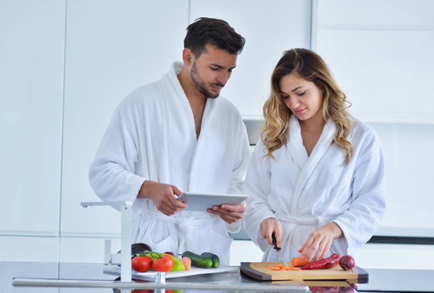 Couple in kitchen using tablet  - Foto, Imagen