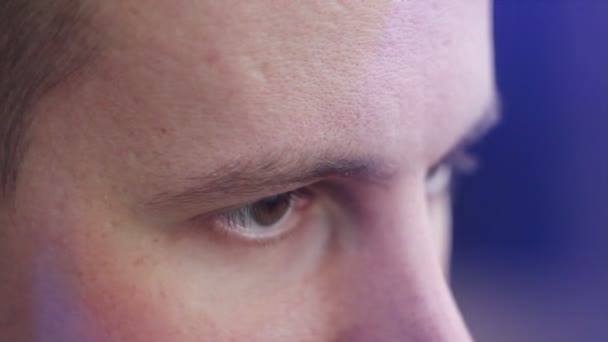 egy fiatal férfi keres, hogy az oldalon, egy számítógép hatása barna szeme - Felvétel, videó