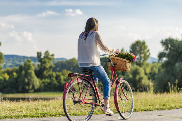 Young smiling woman rides a bicycle - Φωτογραφία, εικόνα