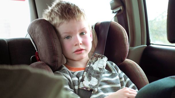 Lindo chico en un asiento de coche para niños
 - Foto, Imagen