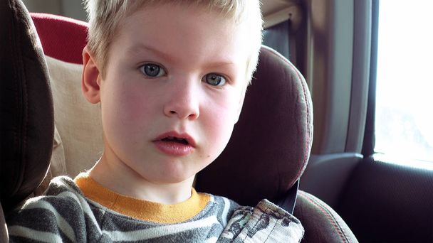 Lindo chico en un asiento de coche para niños
 - Foto, imagen