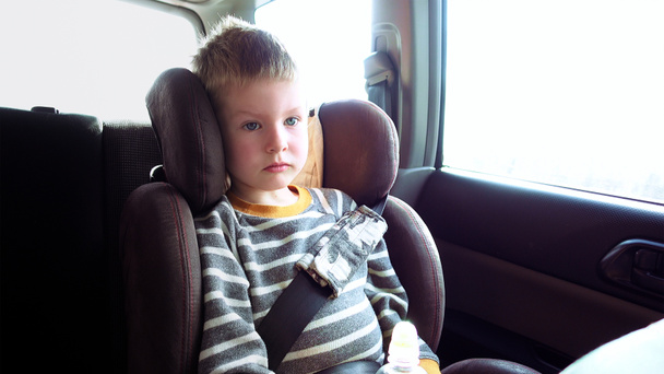 Lindo chico en un asiento de coche para niños
 - Foto, imagen