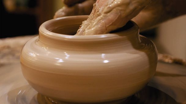 Поттер делает глиняный горшок на гончарном круге
 - Фото, изображение