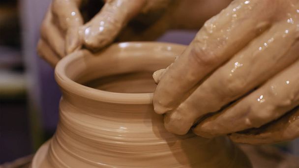 Поттер делает глиняный горшок на гончарном круге
 - Фото, изображение