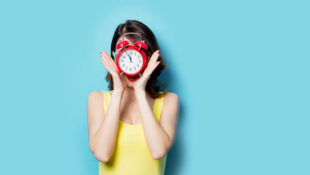 beautiful young woman with alarm clock  - 写真・画像