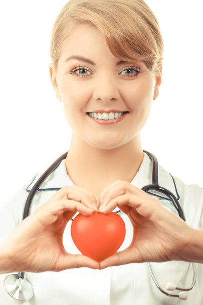 Woman doctor with stethoscope holding red heart, concept of health care - Фото, изображение