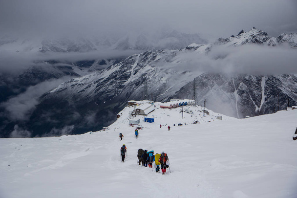 A group of people descends from Mount Elbrus to the base Garabashi - Valokuva, kuva