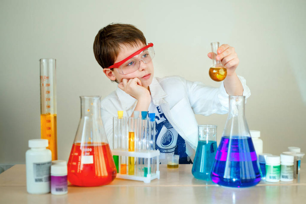 Cute boy is making science experiments in a laboratory - Фото, зображення