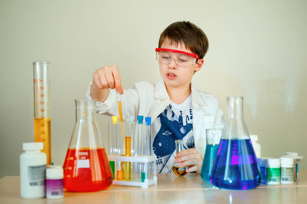 Cute boy is making science experiments in a laboratory - Foto, afbeelding