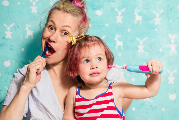 Toothbrush. Mom teaches a little daughter to brush their teeth - Фото, изображение